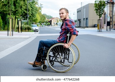 Young Disabled Man In Wheelchair On Road