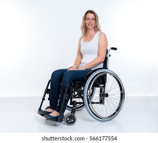 Young Disabled Woman In Wheelchair In Front Of White Background