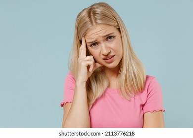 Young disappointed worried sad caucasian blonde woman 20s in casual pink t-shirt prop up forehead look camera isolated on plain pastel light blue background studio portrait. People lifestyle concept - Shutterstock ID 2113776218