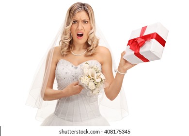 Young displeased bride holding a small wedding present isolated on white background