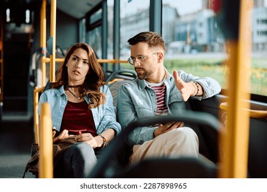 Young displeased couple communicating while traveling by public transport.  - Powered by Shutterstock