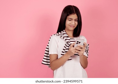 Young dissatisfied teenage girl with bag on pink background in studio. - Shutterstock ID 2394599571