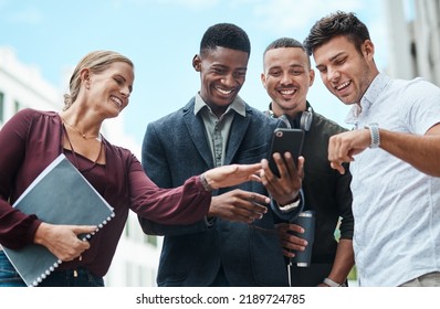 Young, Diverse And Creative Design Team And Their Manager Looking At Phone Together Outside From Below. Female Leader, Boss Or CEO Showing New Staff Or Interns The Company Website During Orientation