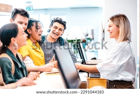 Young diverse friends having fun time at luxury hotel reception on check in time - Travel life style concept with happy people waiting at guesthouse desk on fancy vacation - Bright vivid filter