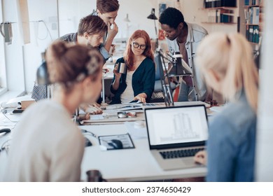 Young and diverse group of architects working on a project together in a startup company office - Powered by Shutterstock