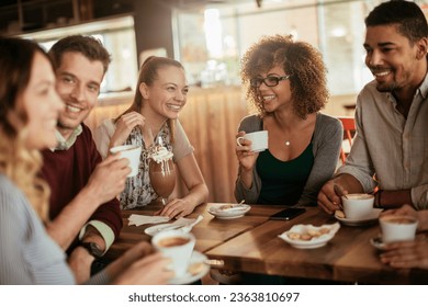 Young and diverse group of friends having a conversation over some coffee and desserts in a cafe - Powered by Shutterstock