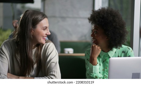 Young diverse group of friends laughing and smiling seated at coffee shop. Women authentic real life laugh and smile at cafe place - Powered by Shutterstock