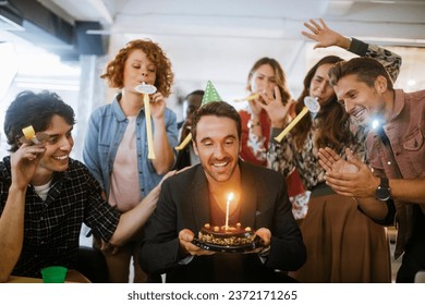 Young and diverse group of people celebrating a surprise birthday party in the office of a startup company - Powered by Shutterstock