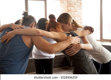 Young diverse people embracing uniting in circle standing together indoors, multiracial team of black and white friends hugging promising help support in common goal achievement, group unity concept - Powered by Shutterstock