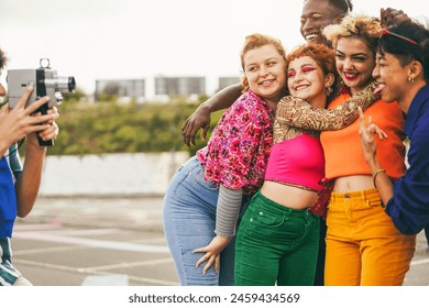 Young diverse people having fun with old vintage video camera outdoor - Main focus on left girls faces
 - Powered by Shutterstock