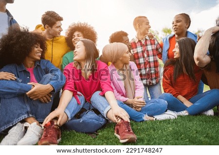 Young diverse people having fun outdoor laughing together - Focus on left african girl face