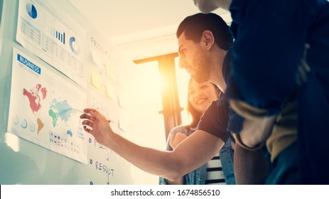 Young Diverse Startup Group Team Brainstorming Together To Briefing Strategic Planning On A Whiteboard Ideas Of Info Graphic Strategies During A Strategy Presentation Session Focused On Business Man.