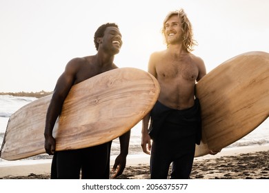 Young diverse surfers having fun on the beach after surf session - People doing extreme water sport - Powered by Shutterstock