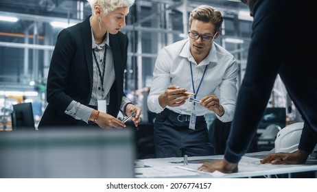 Young Diverse Team Of Automotive Engineers Working In Office At Car Factory. Industrial Designer Talks About Electric Engine Parts With Colleagues, Discussing Different Technological Applications.