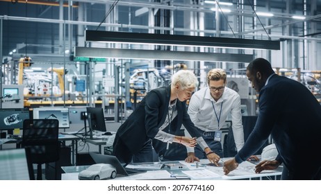 Young Diverse Team of Automotive Engineers Working in Office at Car Factory. Industrial Designer Talks About Electric Engine Parts with Colleagues, Discussing Different Technological Applications. - Shutterstock ID 2076774160