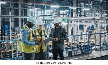 Young Diverse Team of Car Factory Specialists Working on Laptop and Tablet Computers. Engineers Discussing Automotive Industrial Manufacturing Technology on Modern Vehicle Assembly Plant. - Powered by Shutterstock