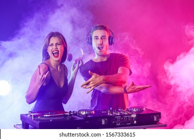 Young djs playing music in nightclub