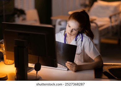 Young doctor analyzing X-ray results on computer for medical assessment. - Powered by Shutterstock