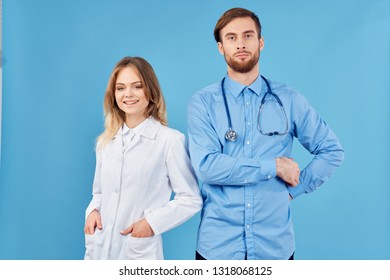 Young doctor in blue shirt and stethoscope around his neck, nurse on blue background                            