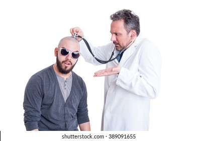 Young doctor checking a silly patient with head problem to establish a diagnostic on white studio background
