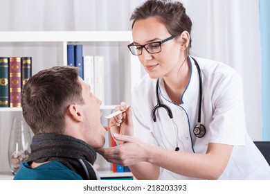 Young Doctor Examining Patient With Sore Throat