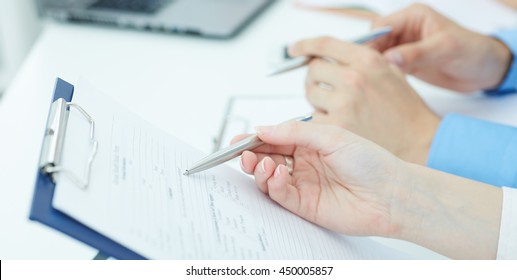 Young doctor explains how to fill out a medical form. Partnership, trust and medical ethics concept - Shutterstock ID 450005857