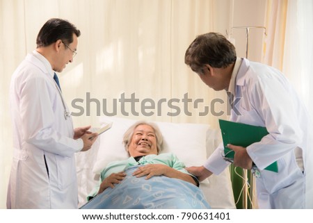 Female doctor filling questionnaire to senior patient