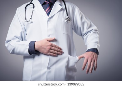 Young Doctor Holding A Pocket For Bribe