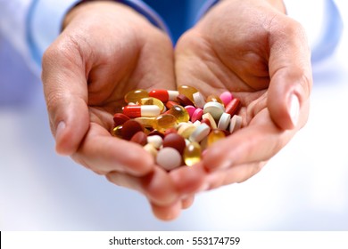 young doctor holds the patient's hand with pills