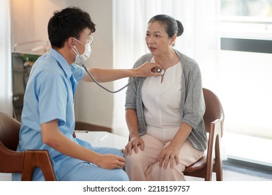 Young Doctor Listening To Lungs Of Patient In Nursing Home