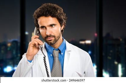 Young Doctor On The Phone At Late Night In His Studio