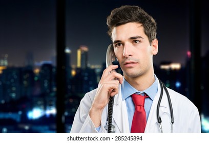 Young Doctor On The Phone At Late Night In His Studio