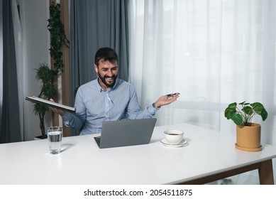 Young Doctor Of Psychology Is Sitting In His Home Office Doing Online Therapy With A Patient And Laughing Because The Patient Told Him A Funny Joke About Psychotherapy