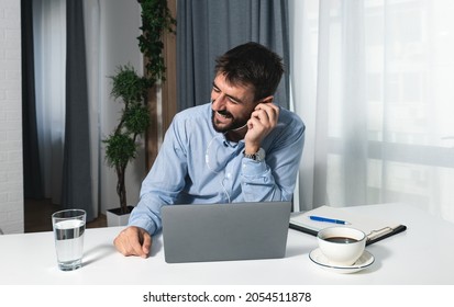 Young Doctor Of Psychology Is Sitting In His Home Office Doing Online Therapy With A Patient And Laughing Because The Patient Told Him A Funny Joke About Psychotherapy