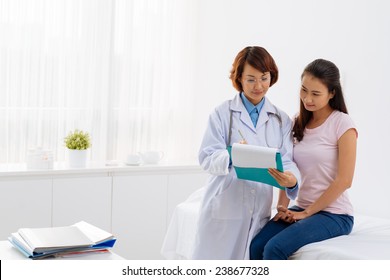Young doctor showing her patient life insurance policy
