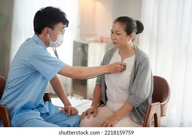 Young Doctor With Stethoscope Checking Heartbeat And Lung Sounds Of Senior Woman