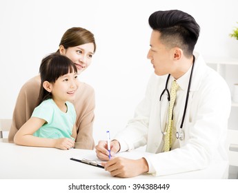 Young Doctor Talking To Young Child And Mother