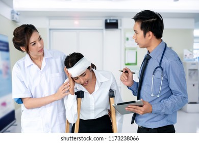 Young Doctor Talking With Female Nursing Assistant And Young Woman Was Injured In The Accident, On Her Head Has Wound And Bandages, She Use Two Crutches To Walking, Clipping Path