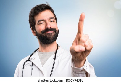 Young Doctor Touching On Transparent Screen On Blue Background