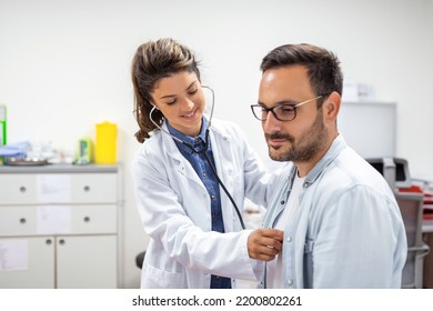 Young doctor is using a stethoscope listen to the heartbeat of the patient. Shot of a female doctor giving a male patient a check up