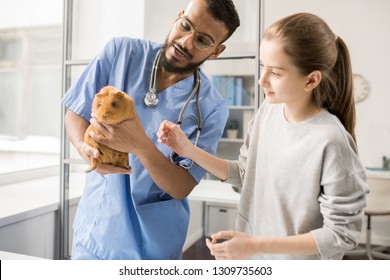 Young doctor of veterinary clinics explaining little girl how to take care of guinea pig health