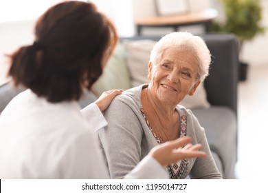 Médico joven visitando a una anciana en su casa