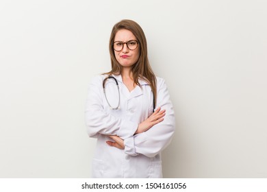 Young Doctor Woman Against A White Wall Unhappy Looking In Camera With Sarcastic Expression.