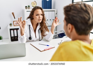 Young Doctor Woman Showing Electronic Cigarette And Normal Cigarrete To Patient Clueless And Confused Expression. Doubt Concept. 