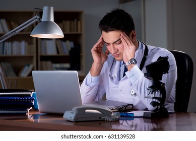 Young Doctor Working Late In The Office