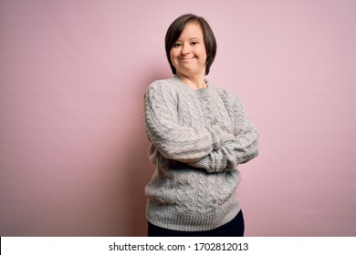 Young down syndrome woman wearing casual sweater over isolated background happy face smiling with crossed arms looking at the camera. Positive person.