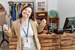 Young Down Syndrome Woman Working As Manager At Retail Boutique Very Happy And Excited Doing Winner Gesture With Arms Raised, Smiling And Screaming For Success. Celebration Concept. 