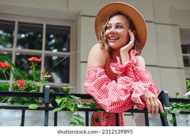 Young dreamful tender smiling happy fun woman 20s wear pink off-the-shoulder dress summer clothes look aside stand on outdoor balcony of town city building People urban summer time lifestyle concept. - Powered by Shutterstock