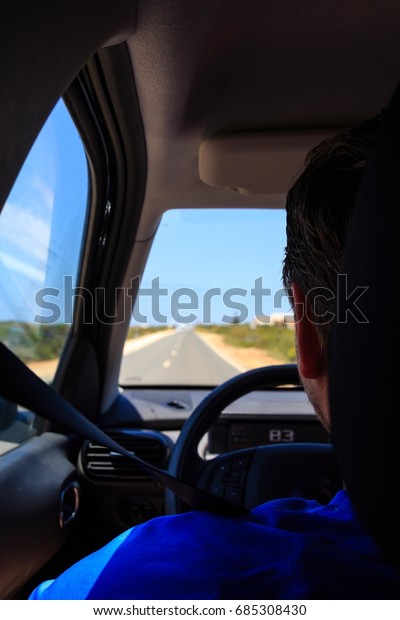 Young driver in the car\
from behind
