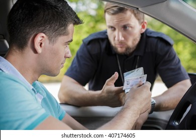 Young driver is giving his ID to the policeman 